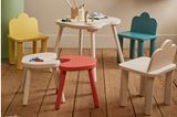 Bunte Stühle, Hocker und ein Tisch mit Malsachen im Kinderzimmer