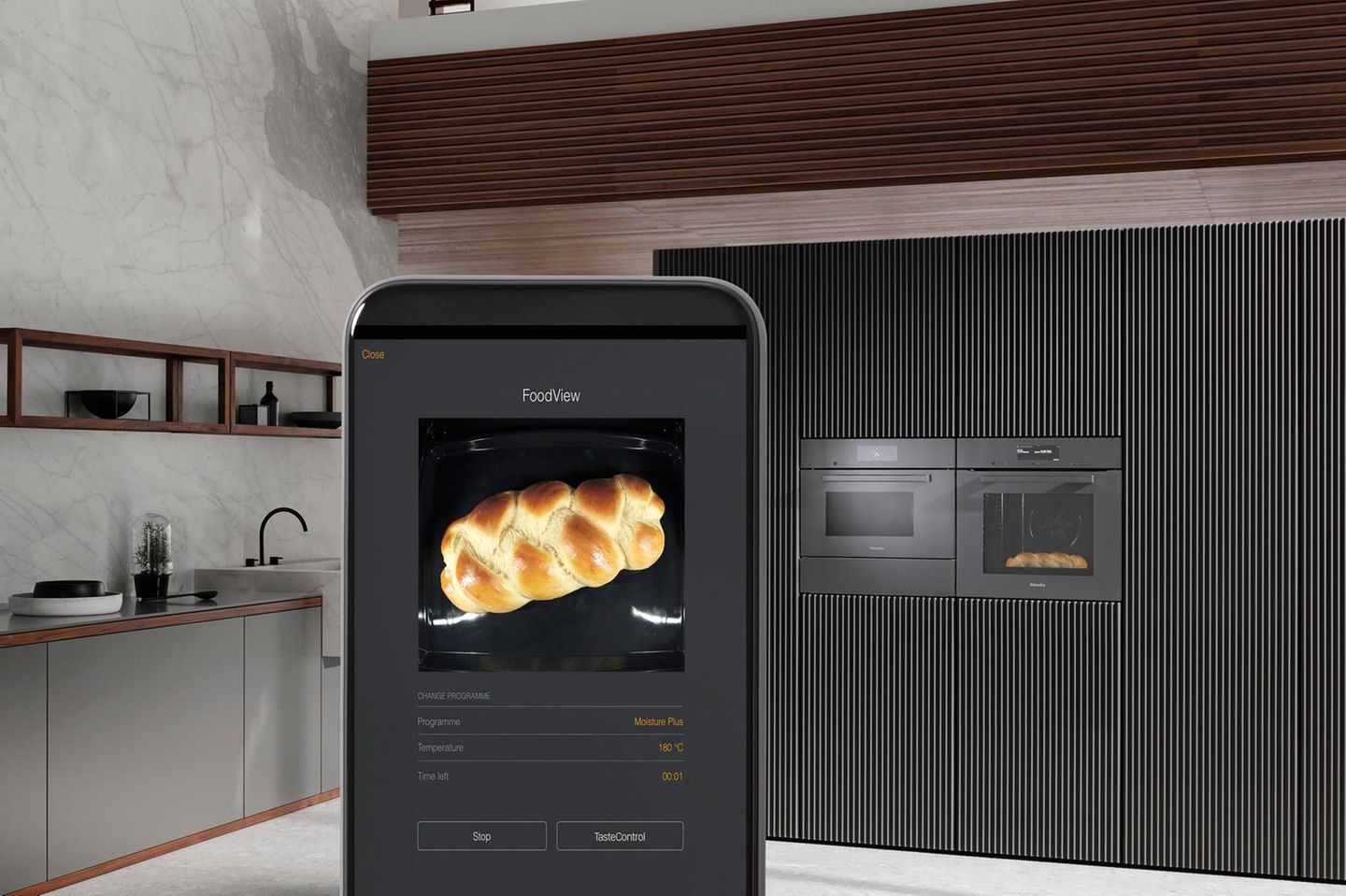 Handydisplay mit Hefezopf, im Hintergrund eine Küche mit Backofen in Grau- und Brauntönen