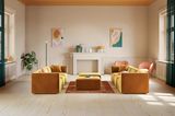 Bernsteinfarbenes Sofa vor beiger Wand