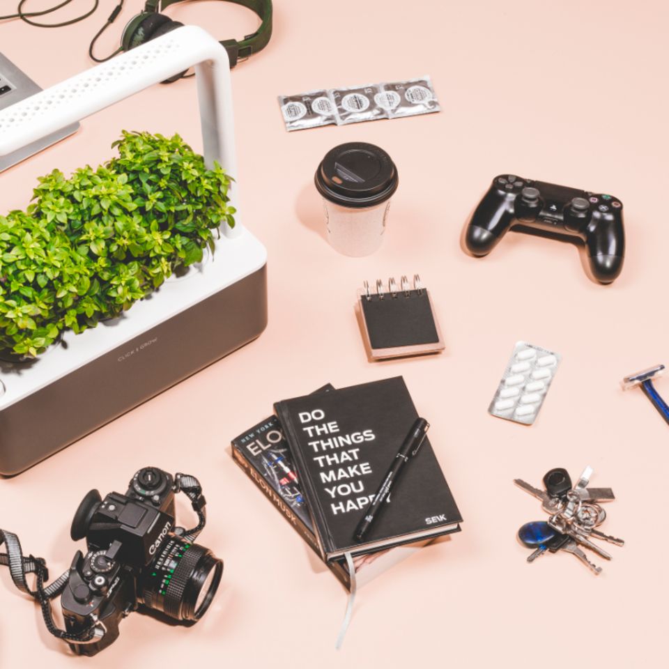 Schreibtisch mit schwarzen Accessoires und Smart Garden mit Kräutern