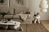 Graues Sofa in einem Wohnzimmer mit braunen Wandfarben und weißen Accessoires