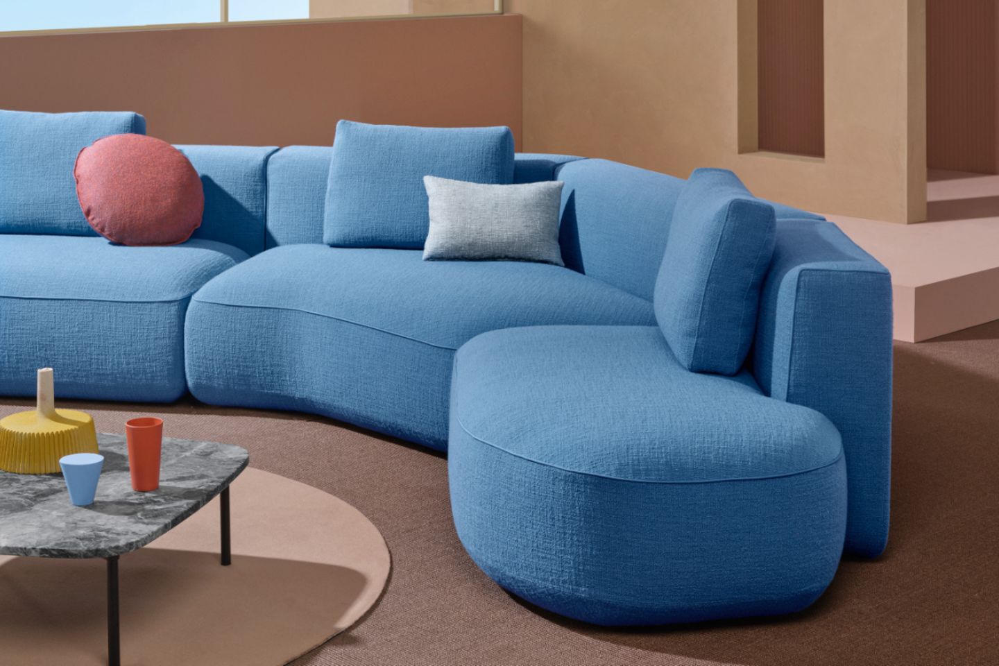 Himmelblaues Sofa mit sanften Rundungen in Terrakottafarbenem Zimmer