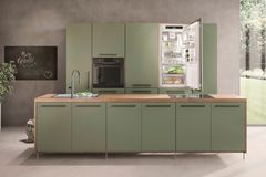 Grüne Küche mit einer Arbeitsplatte aus Holz und einem Liebherr-Kühlschrank