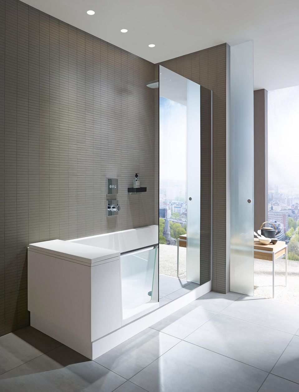Wanne-Dusch-Kombination mit Glastür und Glasabtrennung in einem Badezimer mit antrazitfarbenen Fliesen und bodentiefen Fenstern