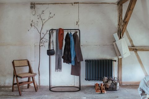 Garderobenständer mit Herbst-Garderobe in Raum mit Heizung und Dachbalken