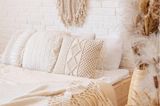 Schlafzimmer komplett weiß gehalten mit Makramee, strukturierten Kissen und Pampasgras-Deko Boho Stil