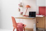 Helles Arbeitszimmer mit Schreibtisch-Regalkombination und rotem Stuhl