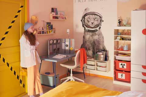 Jugendliches Mädchen an Tür im Teenagerzimmer lehnend, großes Katzenposter an der Wand