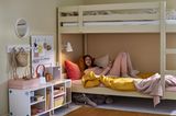 Jugendzimmer mit Schminktisch und Stauraum, Teenagermädchen liegend im Etagenbett