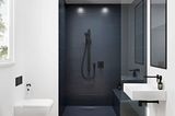 Badezimmer mit weißen Wänden, Holzboden und schwarzer Dusche