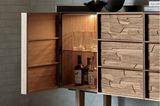 Gefüllter Barschrank aus dunklem Holz mit geöffneter Tür und beleuchtetem Inneren