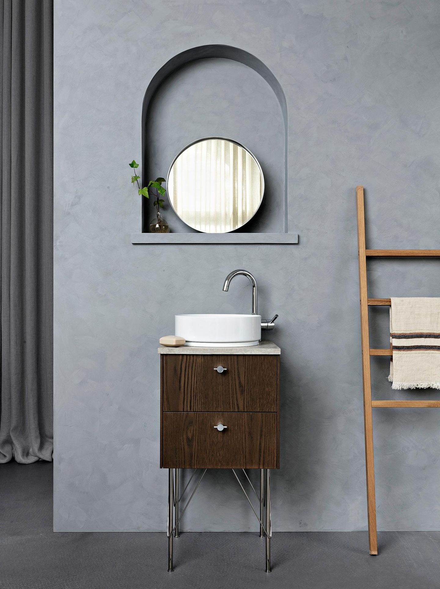 Badezimmer mit kleinem Waschbecken und Unterschrank aus dunklem Holz in grauem Badezimmer