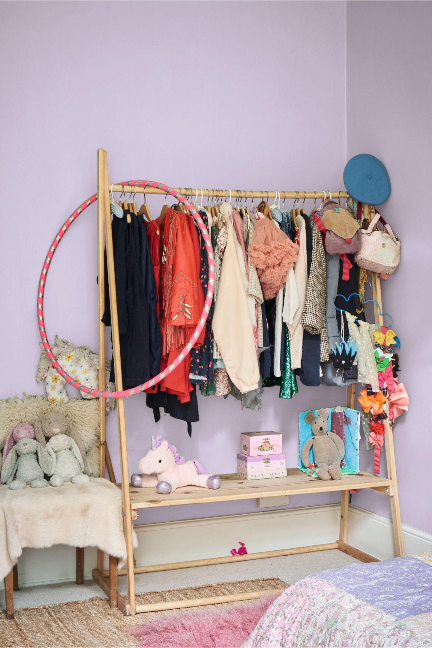 Volle Holzgarderobe im Kinderzimmer mit lavendelfarbenen Wänden und Kuscheltiere
