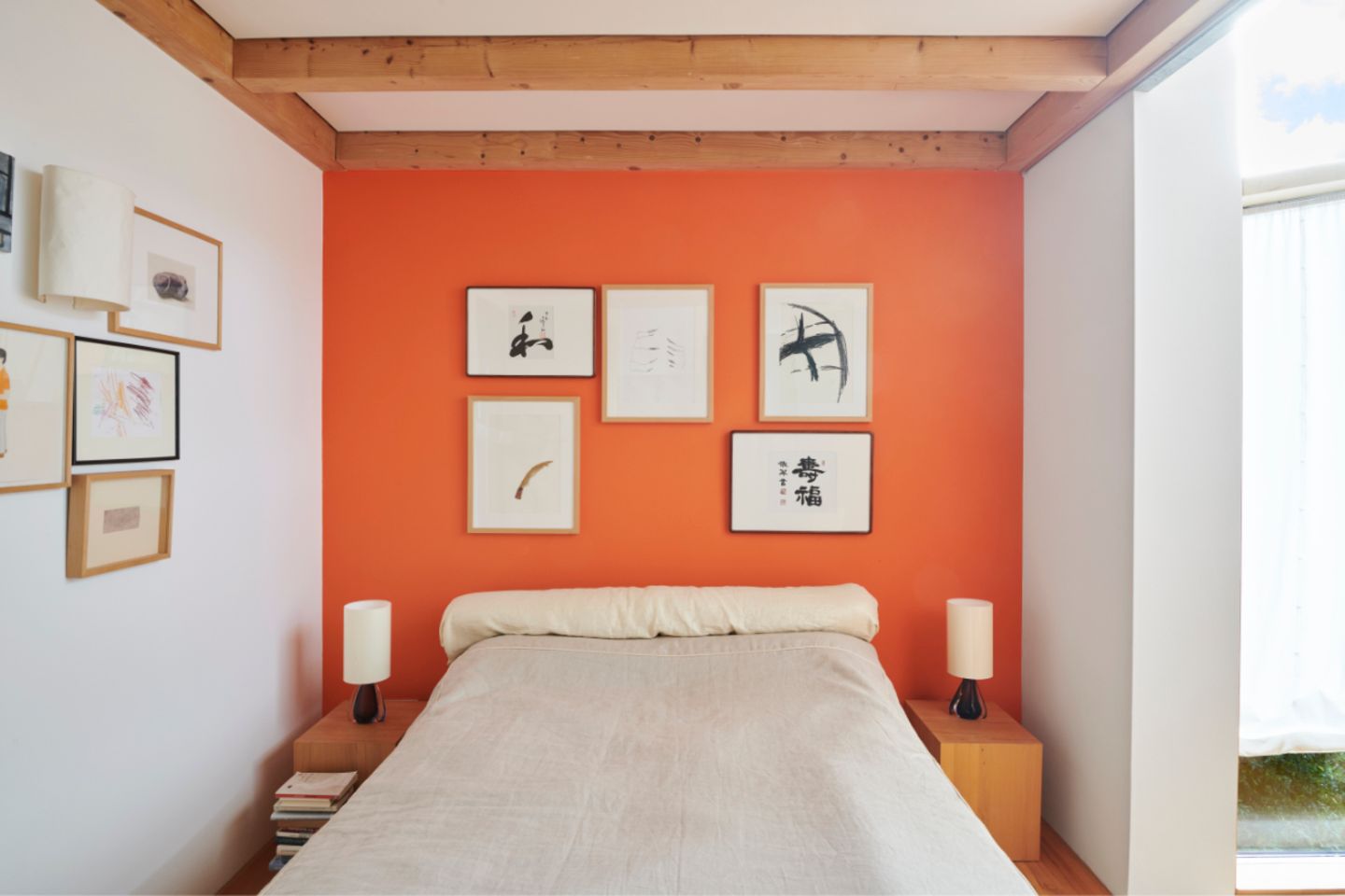 Schlafzimmer in gedeckten Tönen mit Akzentwand in leuchtendem Orange