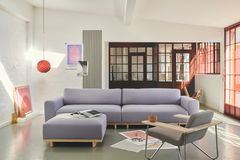 Lavendelfarbenes Sofa in hellem Wohnzimmer mit orangeroten Akzenten