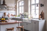 Landhausküche in Hellgrau mit großen Rundbogenfenstern.