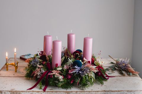 Adventskranz aus Tanne mit rosafarbenen Kerzen auf einem Tisch im Shabby-Chic-Look