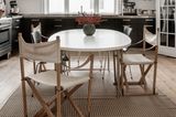 Runder Esstisch mit verschiedenen Stühlen und Designerlampe