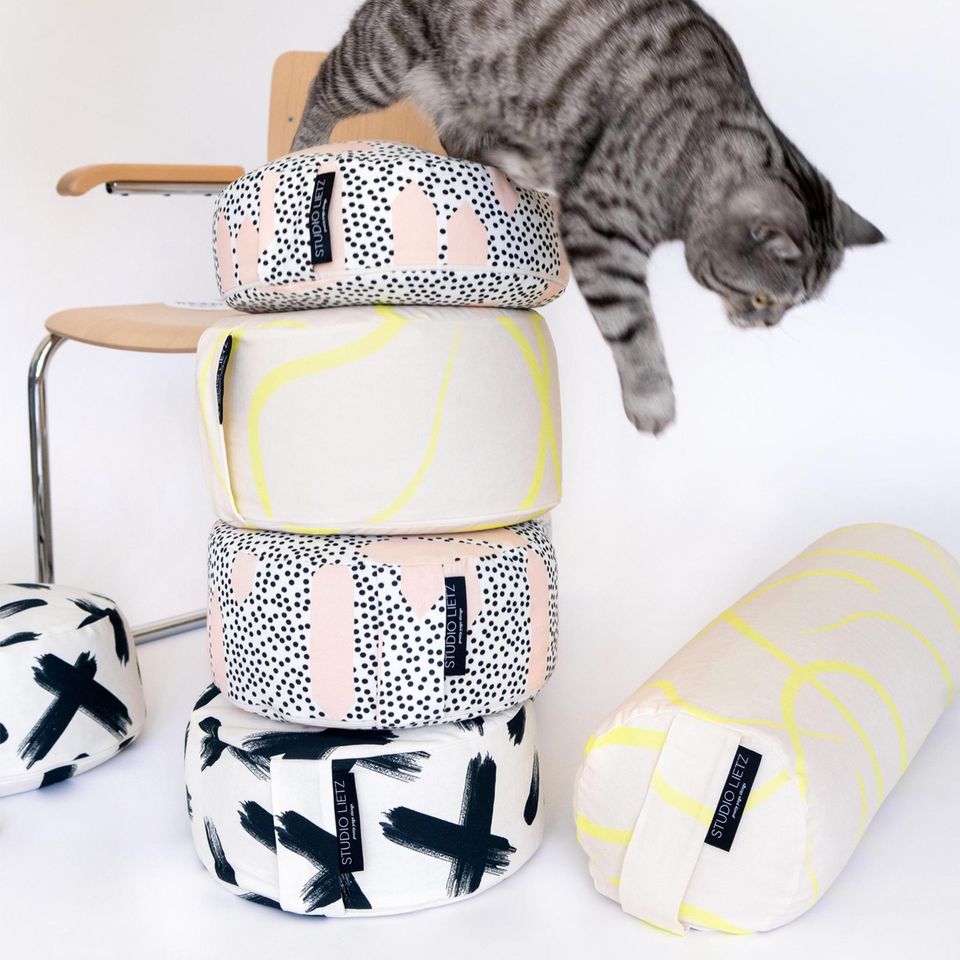 Yoga-Utensilien mit modernen Mustern und einer Katze und einem Stuhl im Hintergrund
