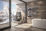 Badezimmer mit Badewanne und Fliesen in Holzoptik mit einem Balkon mit Hängesessel und Bergpanorama im Schnee