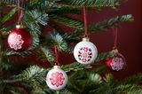 Weihnachtsbaumkugeln in Rot und Weiß mit Muster an einem Weihnachtsbaum