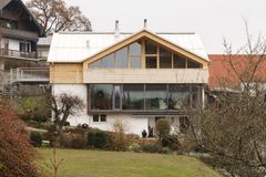 Weißes Haus in Hanglage mit Aufstockung in Massivholzbauweise