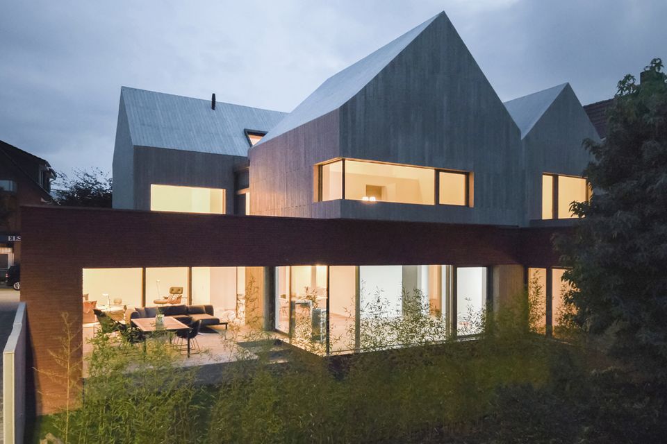 Das "Haus aus Häusern" in Beelen nutzt als Sockelgeschoss ein Bestandsgebäude weiter und fügt drei Aufbauten mit Satteldächern hinzu.