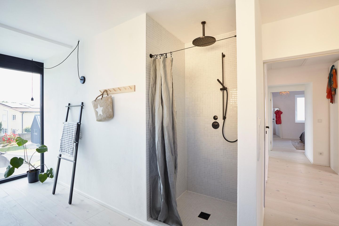 Badezimmer in Grau und Weiß mit schwarzer Regenwasserdusche in einer Nische