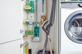Schrank mit Putzmitteln, Staubsauger, Wischern und integrierten Regalen