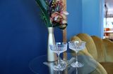 Champagnerschalen aus Glas vor einer blauen Wand und einer goldenen Vase
