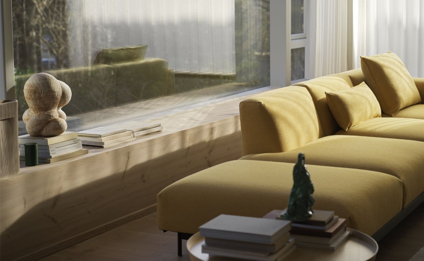 Senfgelbes Sofa vor breitem Sitzfenster mit Büchern auf der Fensterbank