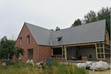 Anbau an ein Einfamilienhaus in Holzrahmenbauweise noch ohne Fenster und mit verwildertem Garten