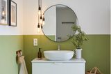 Badezimmer mit halbhoch in Grün gestrichener Wand und Waschtisch in Weiß