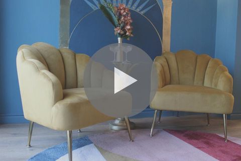 Senfgelbe Sessel vor blauer Wand