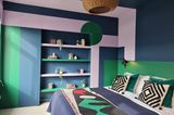 Schlafzimmer mit farbig gestalteten Möbeln und Einbauten