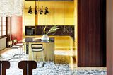 Küche und Theke mit goldenen Fronten und dunklen Holzeinbauten