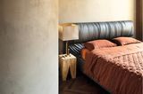 Schlafzimmer mit einem Bett mit Lederhaupt und brauner Bettwäsche