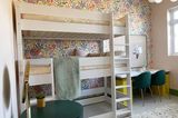 Kinderzimmer mit weißem Hochbett, Blumentapete, Schreibtisch und gestreifter Zimmerdecke