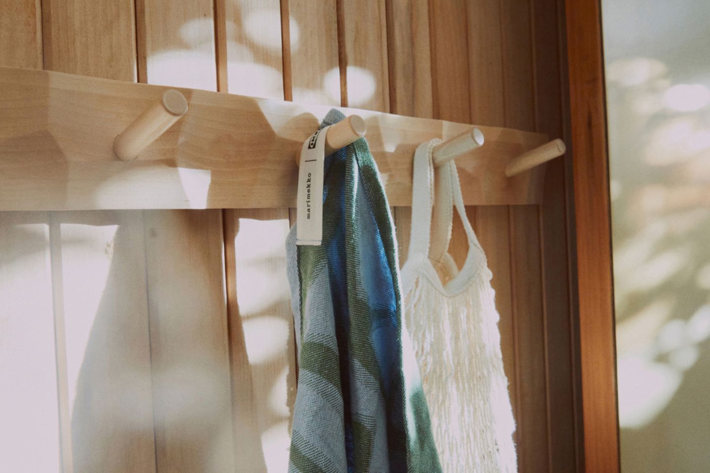 Hakenleiste aus Holz mit Handtüchern und Tasche