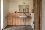 Bad mit lehmfarbener Wand und Holzelementen
