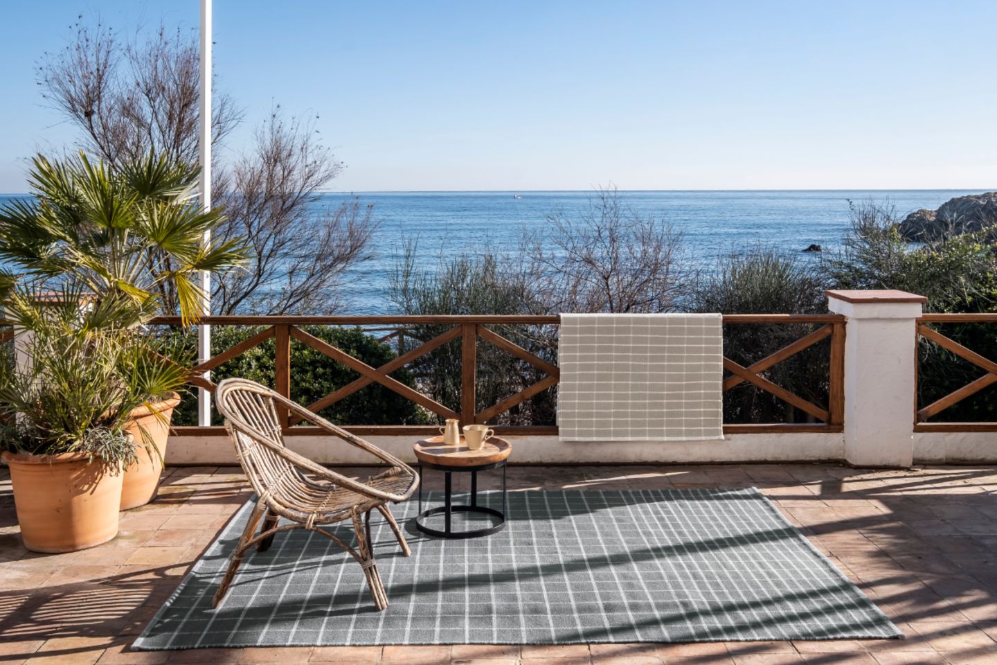 Großer Outdoor-Teppich in Grau auf Terracotta-Terrasse mitBlick aufs Meer