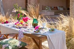 Gedeckter Gartentisch mit bunten Früchten und Blumen