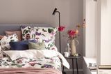 Bettwäsche mit Blüten im beigefarbenen Schlafzimmer