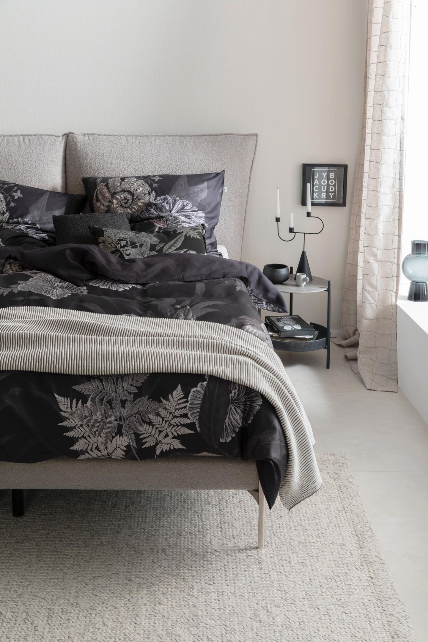Dunkle Bettwäsche mit floralem Muster im hellgrau gestalteten Schlafzimmer