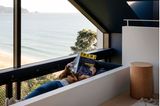 Hängematte unterm Dachgiebel mit lesender Person und Blick auf den Pazifik