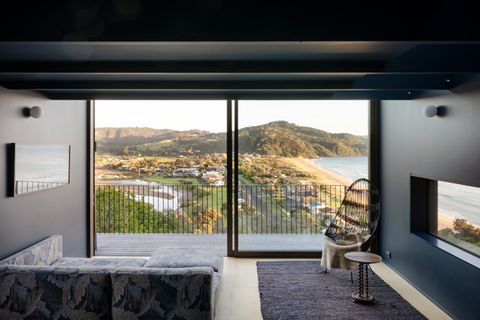 Wohnzimmer mit dunkler Wandfarbe und Blick auf die Küste