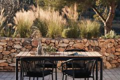 Terrasse mit Steinmauer und Gräsern als Sichtschutz im Hintergrund