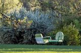 Großer Garten mit zwei Hängesesseln in Grün hängend am Baum