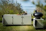 Outdoor-Schrankmodul in salbeigrün mit separatem Grill auf Wiese am Seeufer