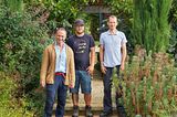 Drei Männer und ein Border Collie im Garten